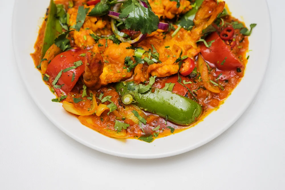 Freshly prepared Indian curry with peppers and coriander